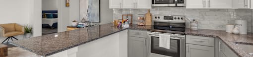 A modern kitchen with a stainless steel oven and microwave.