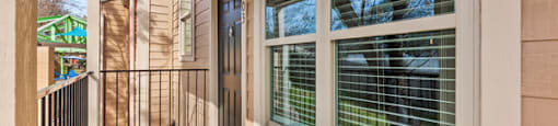 A wooden deck with a sliding glass door and a black railing.