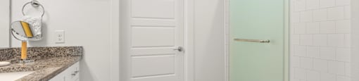 A bathroom with a white door and a green shower.