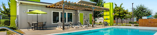 A pool with a yellow building next to it.