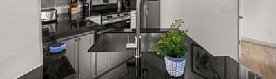 A kitchen with black countertops and white cabinets.