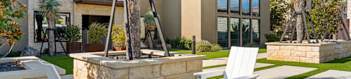 A patio with a table and chairs is in front of a house.
