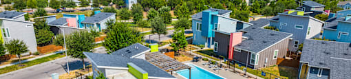 A colorful residential area with a swimming pool and a playground.