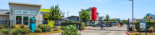 A parking lot with a building and a red and white building in the background.