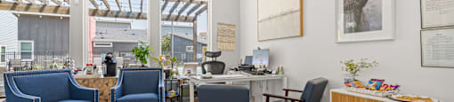 A room with a blue couch, a desk, and a chair.