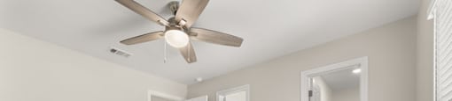 A spacious room with a ceiling fan and carpeted floor.