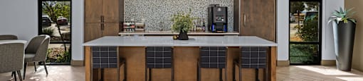 A kitchen with a bar and chairs.