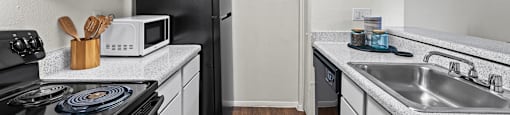 A kitchen with black appliances and white cabinets.