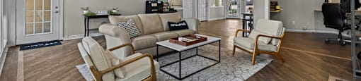 A living room with a couch, chairs, and a coffee table.