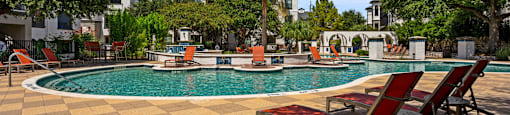 A pool surrounded by trees and chairs.
