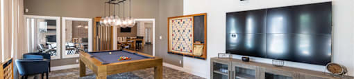 A modern living room with a pool table and a television.