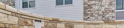 Two grills are placed on a stone wall.