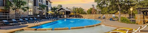A swimming pool surrounded by yellow sun loungers.