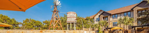 A swimming pool with a windmill and water tower in the background.