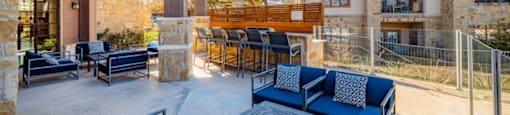 A patio with blue couches and a table.
