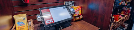 A candy bar sits on a wooden table in front of a monitor.