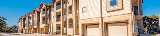 A row of townhouses with garages on the side.