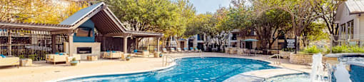 A large outdoor swimming pool with a waterfall feature.