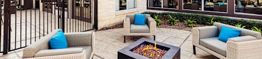 A patio with a fire pit and two couches.