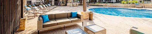 A patio with a pool and furniture.