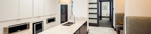 A modern kitchen with a marble countertop and a dining area with a bench.