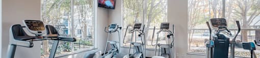 A gym with treadmills, exercise bikes, and elliptical machines.
