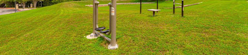 A park with a bench, a pull-up bar, and a pole.
