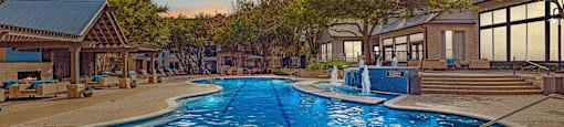 A large outdoor swimming pool surrounded by trees and buildings.