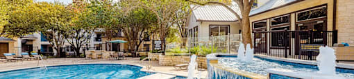 A large outdoor swimming pool with a waterfall feature.