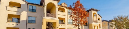A large apartment complex with a green lawn in front.
