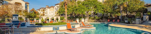 A pool area with a small pool and sun loungers.