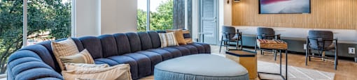 a living room with blue couches and a table with chairs and a large window