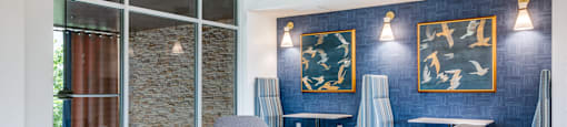 a living room with blue chairs and a blue accent wall