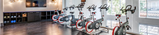 a fitness room with spin bikes and a tv