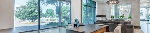 a home office with a large window overlooking a living room