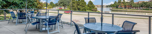 a patio with tables and chairs and umbrellas