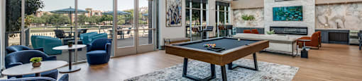 an open living room with a pool table and large windows