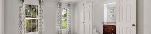 view of bedroom with two windows and restroom access at Forest Vista, Texas, 77571