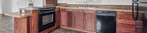A kitchen with wooden cabinets and black appliances.