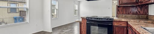 A kitchen with wooden cabinets and a black oven.