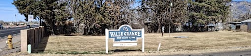 A sign that says Valley Grande stands in front of a grassy area.