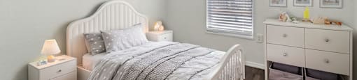 A bedroom with a bed, nightstand, and a dresser with drawers.