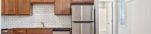 a kitchen with wooden cabinets and a stainless steel refrigerator