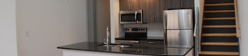 A kitchen with a stainless steel refrigerator and stove.