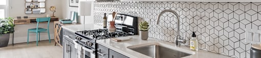A kitchen with a stove top oven and a sink.