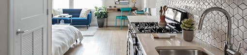 A kitchen with a stove top oven and a sink.