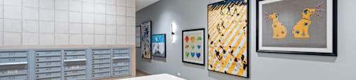 A reception area with a white counter and artwork on the wall.