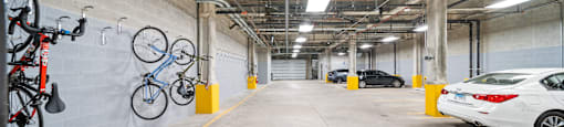 A parking garage with a white car and bicycles.