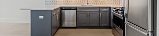 A kitchen with a refrigerator on the right side.