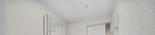 A white bathroom with a toilet, sink, and mirror.